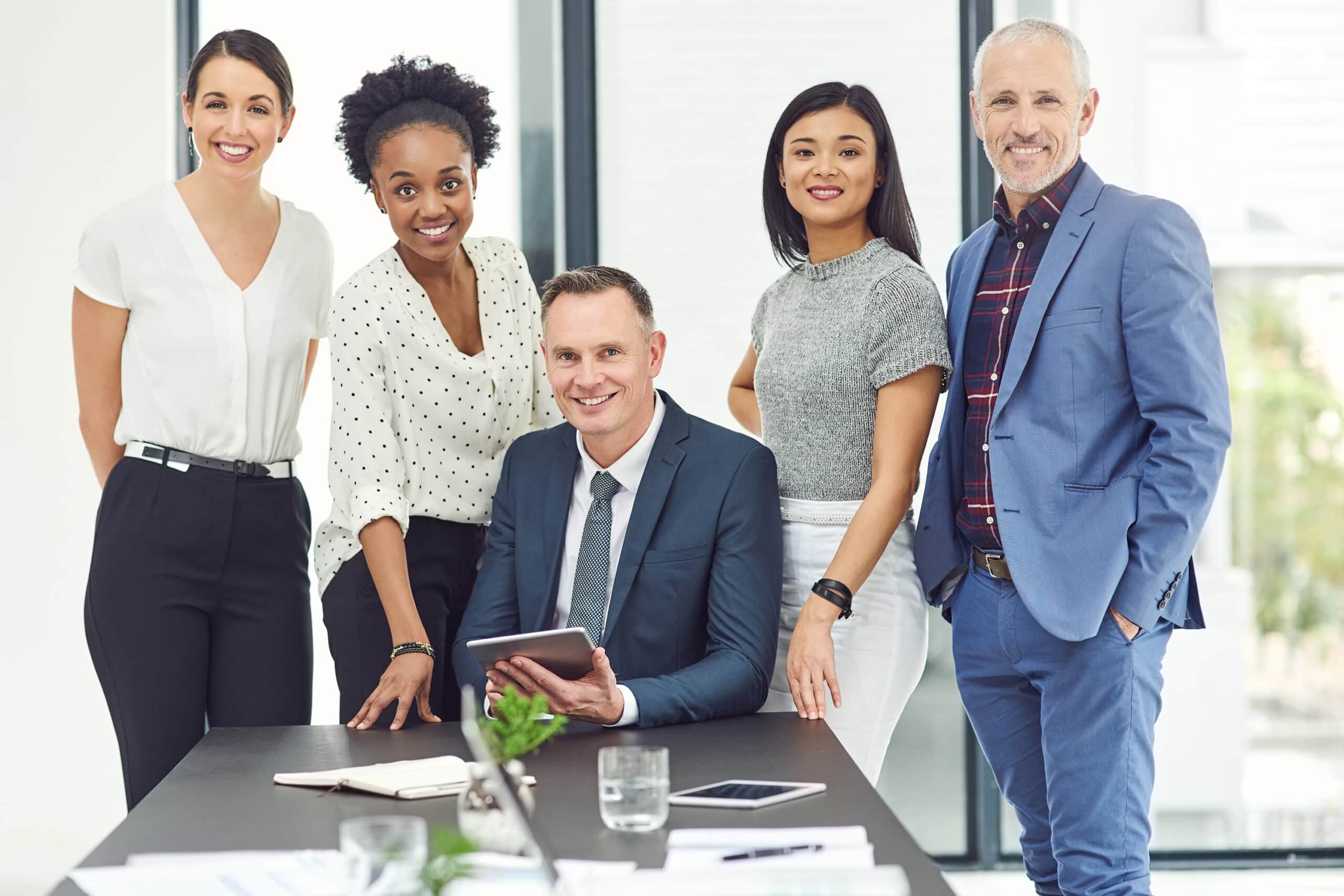 Five happy employees wearing corporate attires in the office.