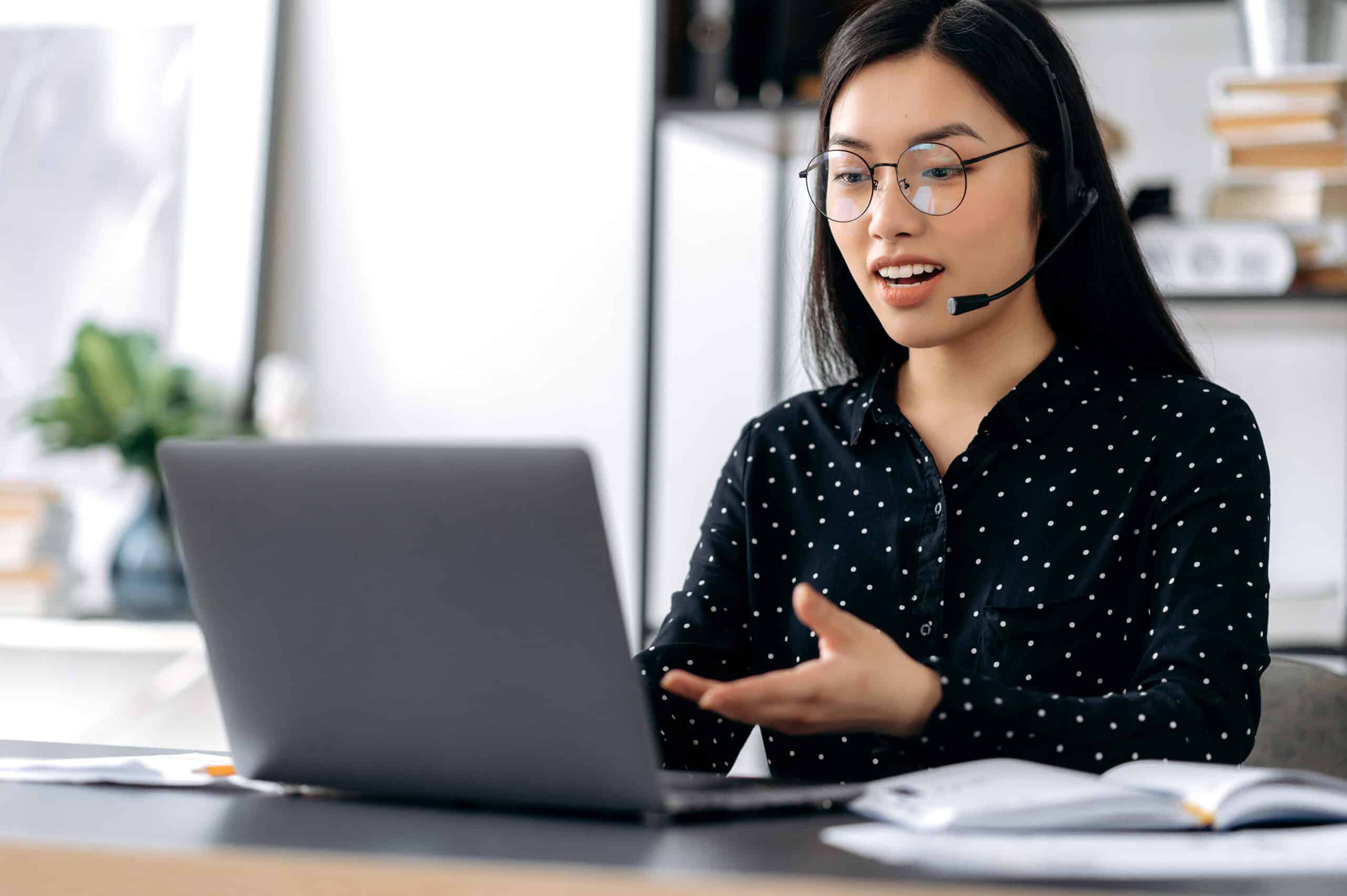 A contact center associate actively serving a client with her laptop.