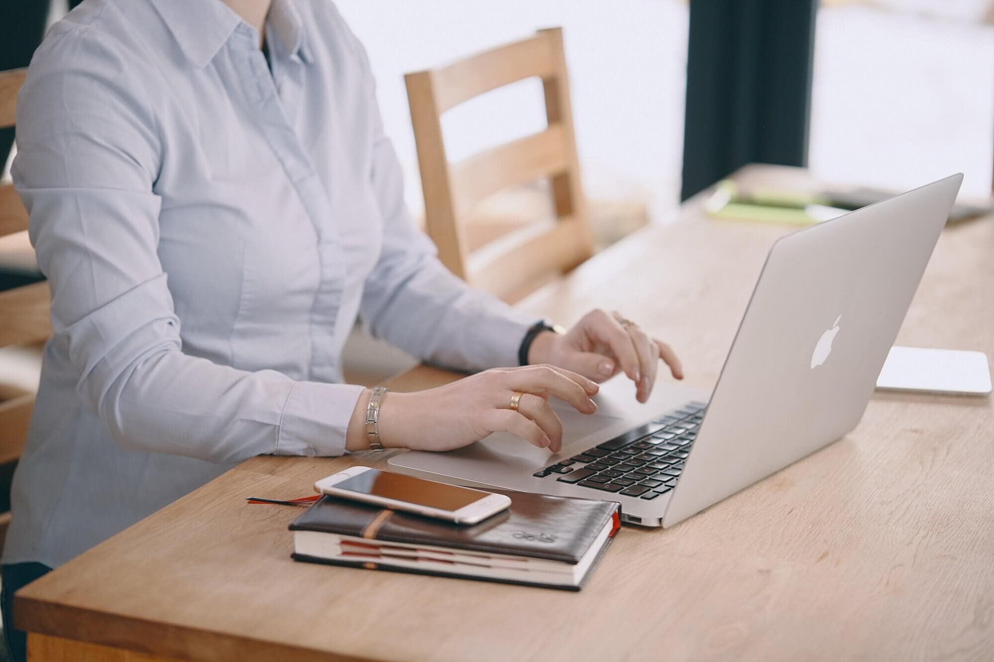 A close up of a person typing on a laptop.