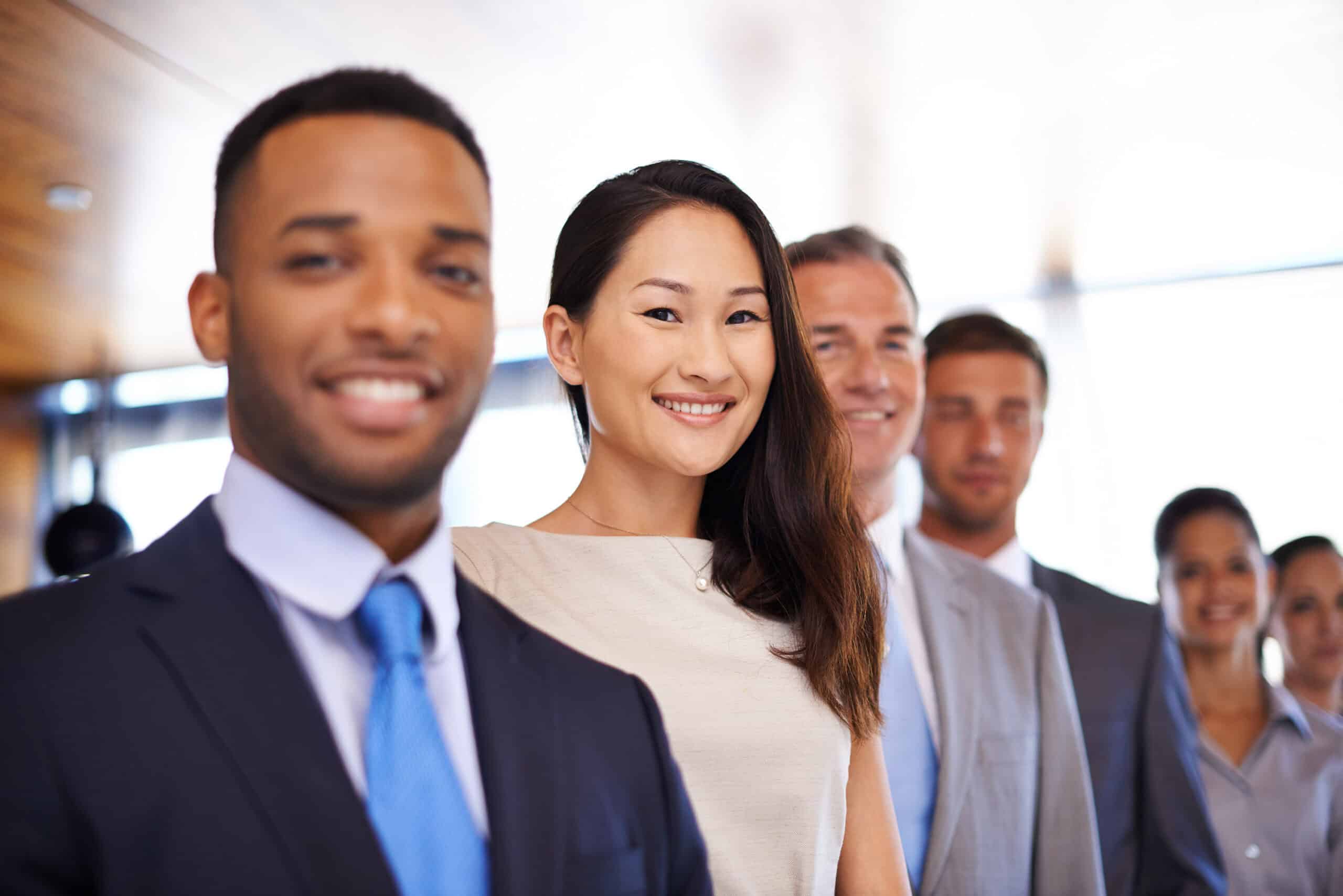 Six diverse people are lined up while wearing their office attire.