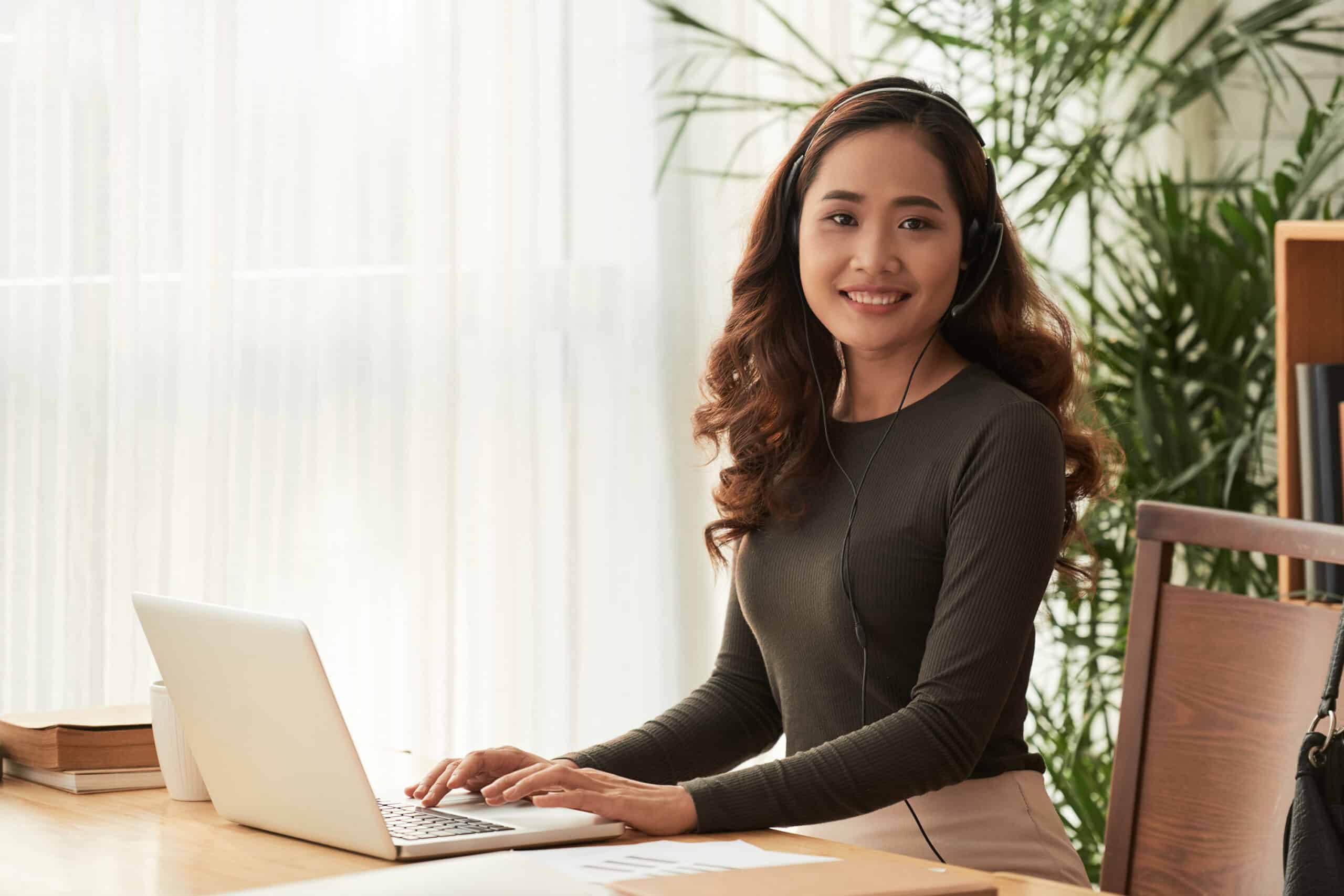 A contact center associate joyfully working at her home office.